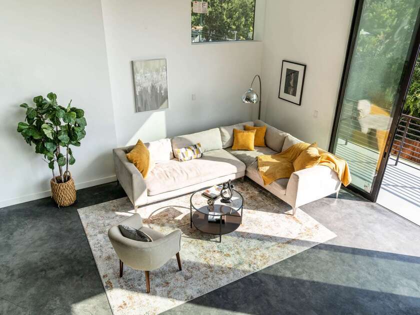 Bright contemporary living room with sectional seating, glass coffee table, and patio views in Greater Pasadena, CA.