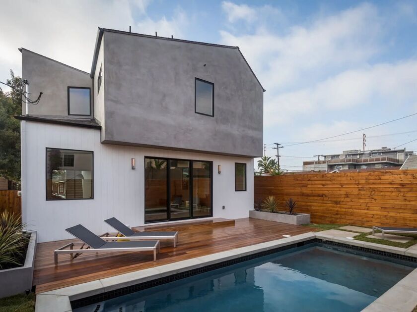 Contemporary Los Angeles home with sliding glass doors, pool, wood deck, and outdoor lounge chairs