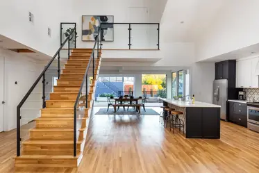 Black metal and glass stair railing in a modern open-plan home